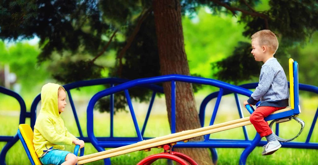 two children balancing on see-saw